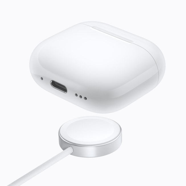 AirPods 5 med trådløst ladeetui over en Apple Watch-lader